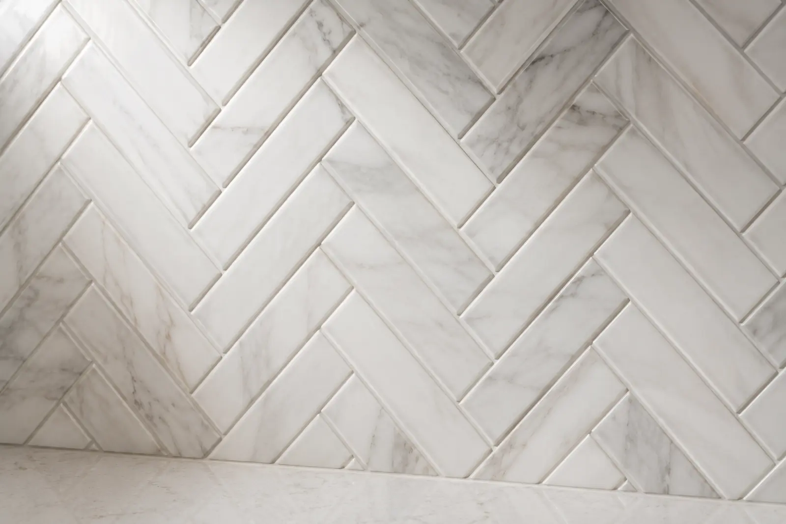 Herringbone pattern marble backsplash tile with clean mitered edges